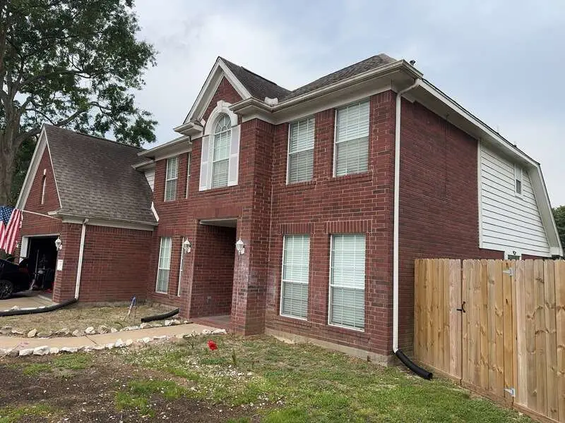 Houston home with damaged siding, roof, and gutters before JC&C Roofing Company restoration